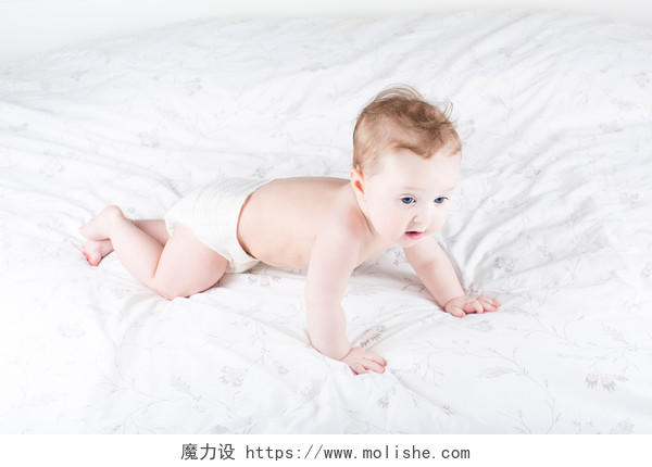 有趣的婴儿在一张白色的床上爬